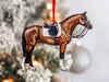 a horse ornament hanging from a christmas tree